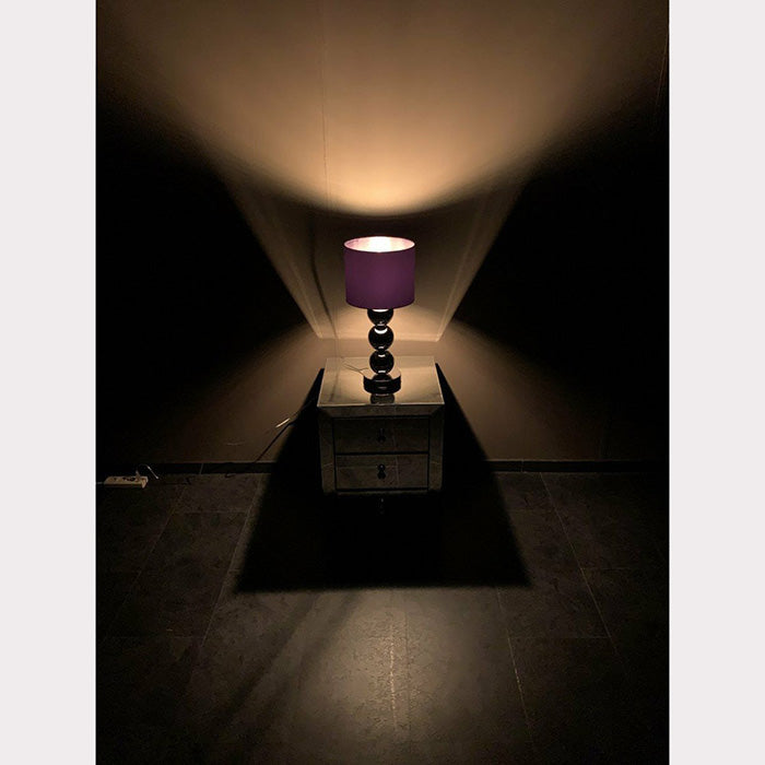 Kleine chroom bollamp tafelmodel in het donker met verlichting aan