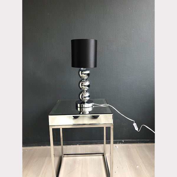 Kleine chroom bollamp tafelmodel op een chromen tafel